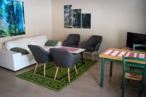 a living room with a table and chairs and a couch at Hostelli Havumaja in Puumala