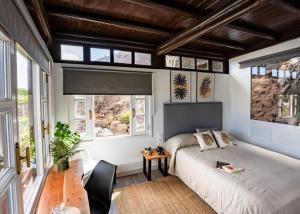 a bedroom with a bed and a table and windows at Casona de Tao in Tiagua +94 photos