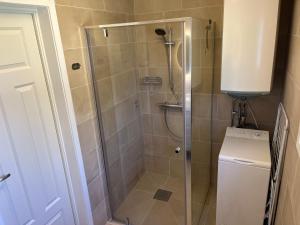 a shower with a glass door in a bathroom at Stuga i vassemåla in Vimmerby