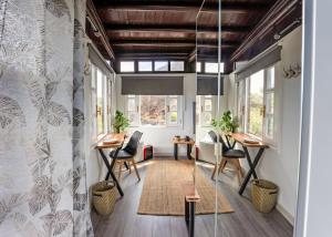 a room with tables and chairs and windows at Casona de Tao in Tiagua