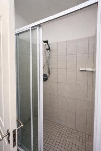 a shower with a glass door in a bathroom at Goose Valley Golf Estate D7 in Plettenberg Bay +23 photos
