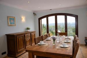 a dining room with a wooden table and chairs at Villa Lavendel in Montauroux