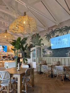 a restaurant with tables and chairs and a sign on the wall at Goose Valley Golf Estate D7 in Plettenberg Bay