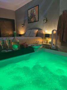 a room with a tub with a bed and a bedroom at La Maison Coloniale Suites privatives de prestige in Torreilles