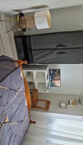 a bedroom with a bed and a desk and a ceiling at Mais pour ce jour in Brest