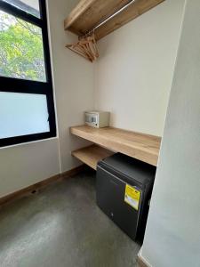 a room with a small refrigerator and a window at Akela Park Hotel in Medellín