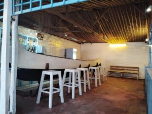 a row of white stools in a room with a table at Pirogue D'or in Morombe