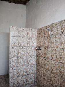 a shower in a bathroom with a stone wall at Pirogue D'or in Morombe