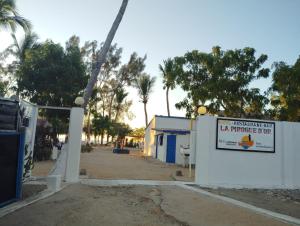 a sign on a wall next to a street at Pirogue D'or in Morombe