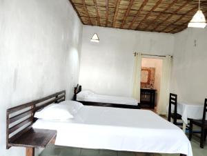 a bedroom with a large bed and a table and chairs at Pirogue D'or in Morombe