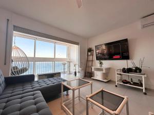 a living room with a couch and a large window at Manhattan apartment in Empuriabrava