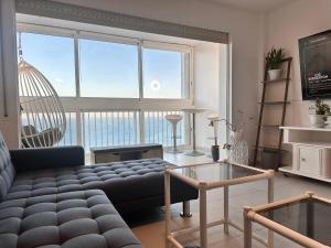 a living room with a couch and a large window at Manhattan apartment in Empuriabrava