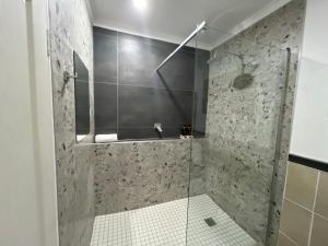 a bathroom with a shower with a glass door at Makiti Retreat in Polokwane +11 photos