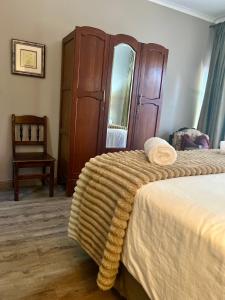 a bedroom with a large bed and a chair at Makiti Retreat in Polokwane