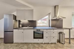 a kitchen with white cabinets and a sink at Garnet Penzion in Olomouc
