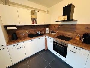 a kitchen with white cabinets and a wooden counter top at FeWo Wanderlustig in Wolfstein