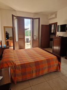 a bedroom with a bed and a sliding glass door at La Cambusa B&B in Cocumola
