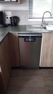 a dishwasher in a kitchen next to a sink at Chalet De Bosrand Gasselte in Gasselte +17 photos