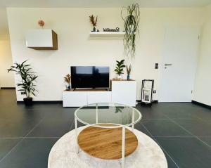a living room with a glass table and a tv at FeWo Wanderlustig in Wolfstein