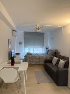 a living room with a bed and a couch at Luminoso Estudio en la playa de el Campello in El Campello
