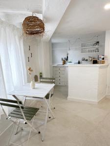 a kitchen with a white table and chairs in a room at Loft en Binibeca in Binibeca +14 photos