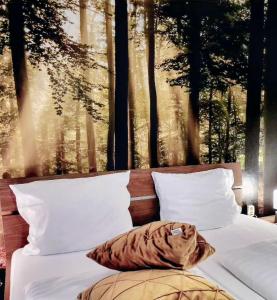 a bedroom with a bed with a picture of trees at Pension Waldschloß in Holzminden