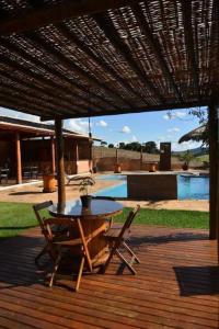 a patio with a table and chairs under an umbrella at Pousada Morada do Sol in Socorro