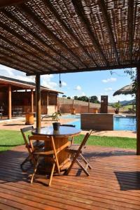 a wooden deck with a table and chairs under a roof at Pousada Morada do Sol in Socorro +59 photos