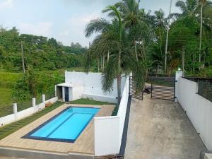 a swimming pool in the backyard of a house at Omik Residence in Dinapamunuwa