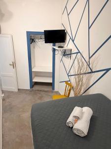 a bedroom with a bed with two towels and a television at Palazzo delle Logge in Palermo