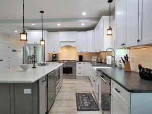 a kitchen with white cabinets and a large kitchen island at The Sunrise On Sunset in West Cape May