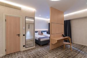 a hotel room with a bed and a desk and a bedroom at Renion Almaty Hotel in Almaty