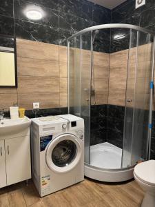 a bathroom with a washing machine and a shower at Vokzalna in Mukacheve