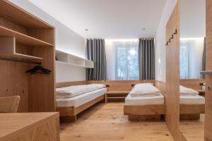 a bedroom with two beds and a window at Plan de Corones Apartment in San Sigismondo
