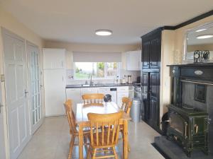 a kitchen with a table and chairs and a stove at Gweedore Seaview Cottage in Bun na Leaca