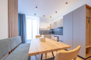 a kitchen and dining room with a wooden table and chairs at Plan de Corones Apartment in San Sigismondo
