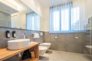 a bathroom with a sink and a toilet and a mirror at Plan de Corones Apartment in San Sigismondo +33 photos