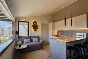 a kitchen and living room with a couch and a table at Casa Cinzia in Gravedona