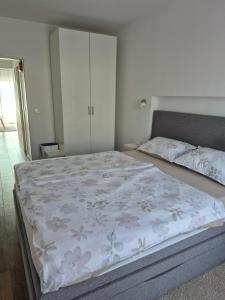 a bedroom with a large bed with a floral bedspread at Apartman Luka in Novigrad Istria