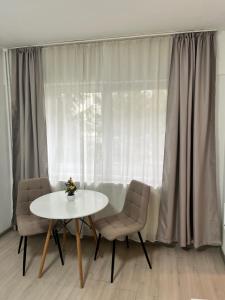 a table and chairs in front of a window at Focus Home in Miercurea-Ciuc