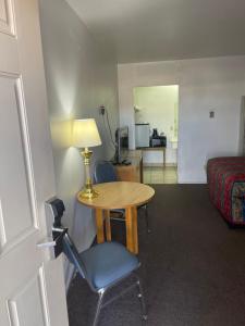 a hotel room with a table and chair and a bed at Economy Inn Motel in Kingman