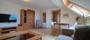 a living room with a flat screen tv and a table at Forsthaus Stagnieß in Ueckeritz