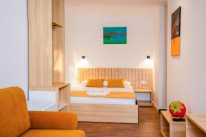a bedroom with a bed and a couch at Zoe Hotel in Prishtinë