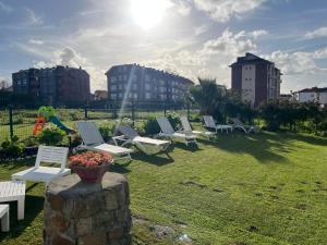 a group of lawn chairs and a bowl of flowers on a wall at Apartamentos El Valle in Suances