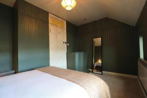 a bedroom with a white bed and a bathroom at Thrush Cottage in Schull