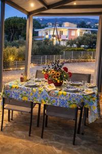 a table with a blue and white table cloth and flowers on it at Sadova Messinia Pearl Cozy Seafront House in Avía
