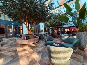 a lobby with couches and chairs in a building at Eilandhotel Texel - Nieuw geopend hotel in De Cocksdorp +67 photos