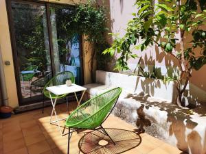 a green chair and a table on a patio at Bellver bedrooms in Xàtiva