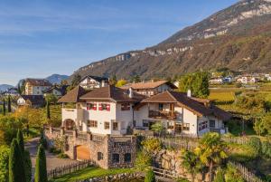 a house in a village with mountains in the background at Weinberghof in Termeno