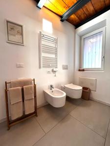 a bathroom with a sink and a toilet and a window at Perla Loft in Seriate